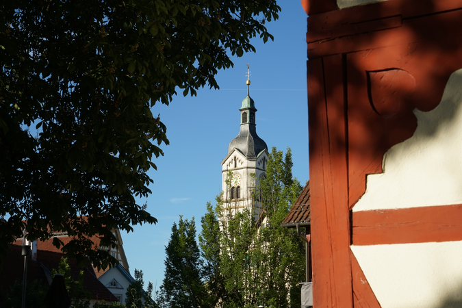 018_002 Hinter einer Fachwerkfassade steht in der Ferne ein historischer Kirchturm