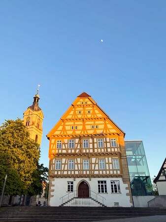 019_005 Das Bild zeigt ein historisches Gebäude und eine Kirche in einer strahlenden Abendstimmung