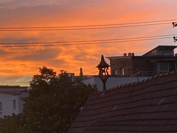 Ein imposanter Abendhimmel mit Sonnenuntergang beleuchtet Häuser