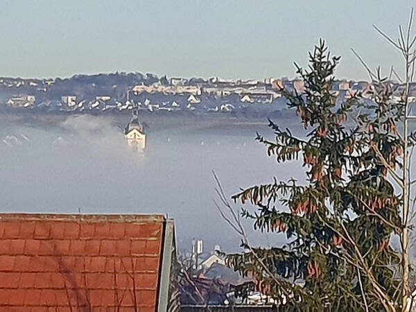 029_002 Ein Kirchturm ragt aus einer tiefliegenden Nebelwand hervor