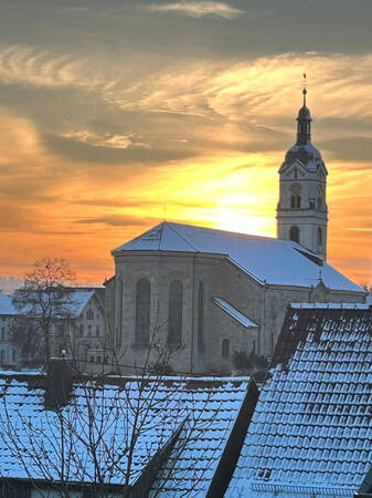 6. Platz Roberto Schiazza: Das Bild zeigt einen beeindruckenden winterlichen Sonnenuntergang, eine historische Kirche und schneebedeckte Dächer
