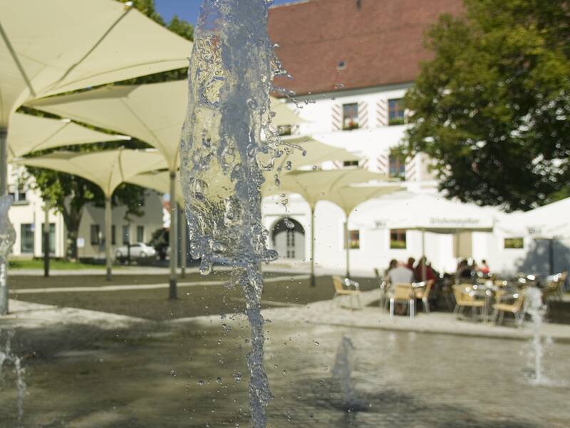 Das Rathaus am Schlossplatz mit Wasserspielen im Vordergrund